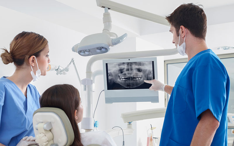 Dentist pointing at dental x-ray