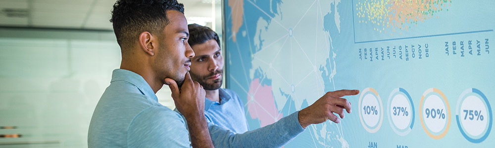 Two men looking at a map of the world with data