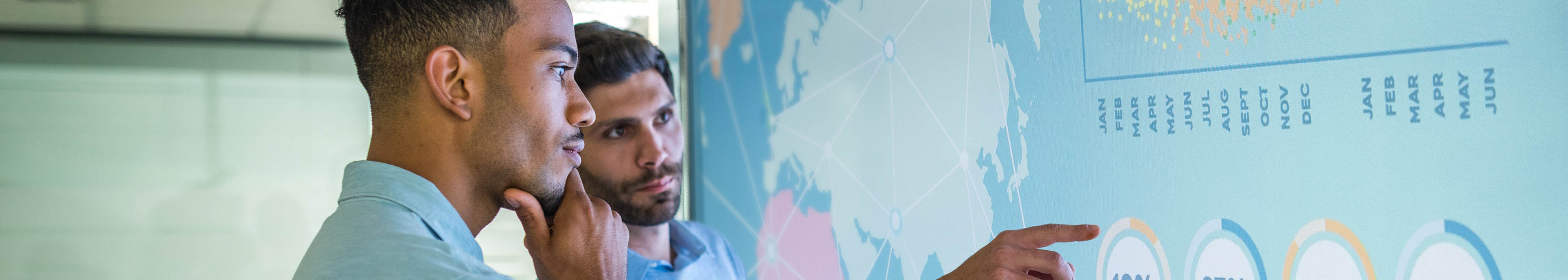 Two men looking at a map of the world with data