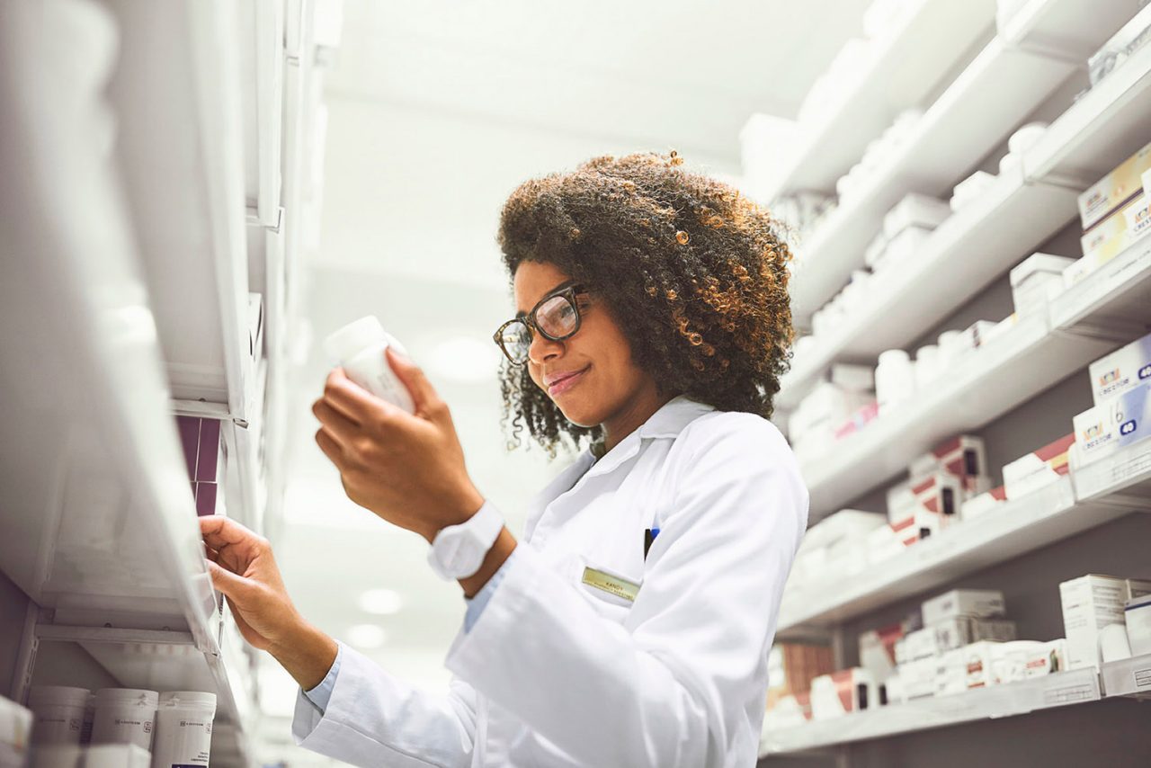 Pharmacist looking at a prescription bottle